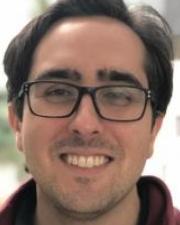 Man with short dark hair, wearing glasses and a red button-down shirt
