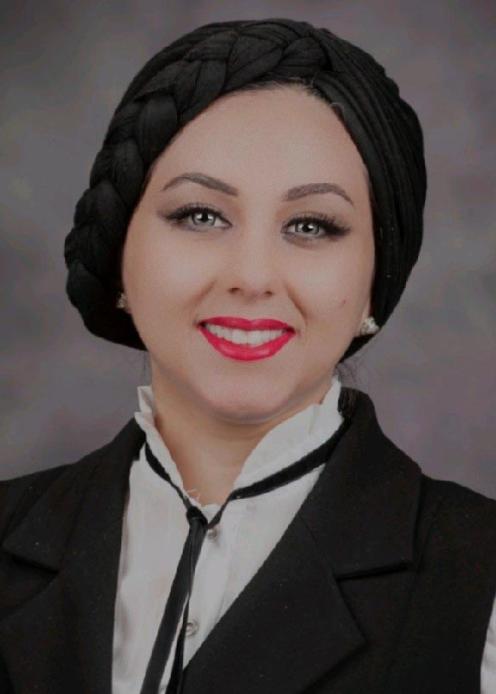 Woman with black hijab, wearing a white button-down shirt and a black vest